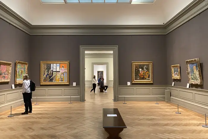 One person is seen in a gallery at the Metropolitan Museum of Art, with two others in an adjoining gallery